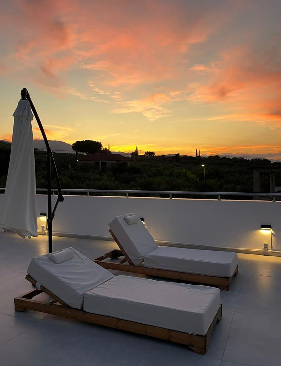 Sun loungers on the rooftop under a dramatic sunset sky