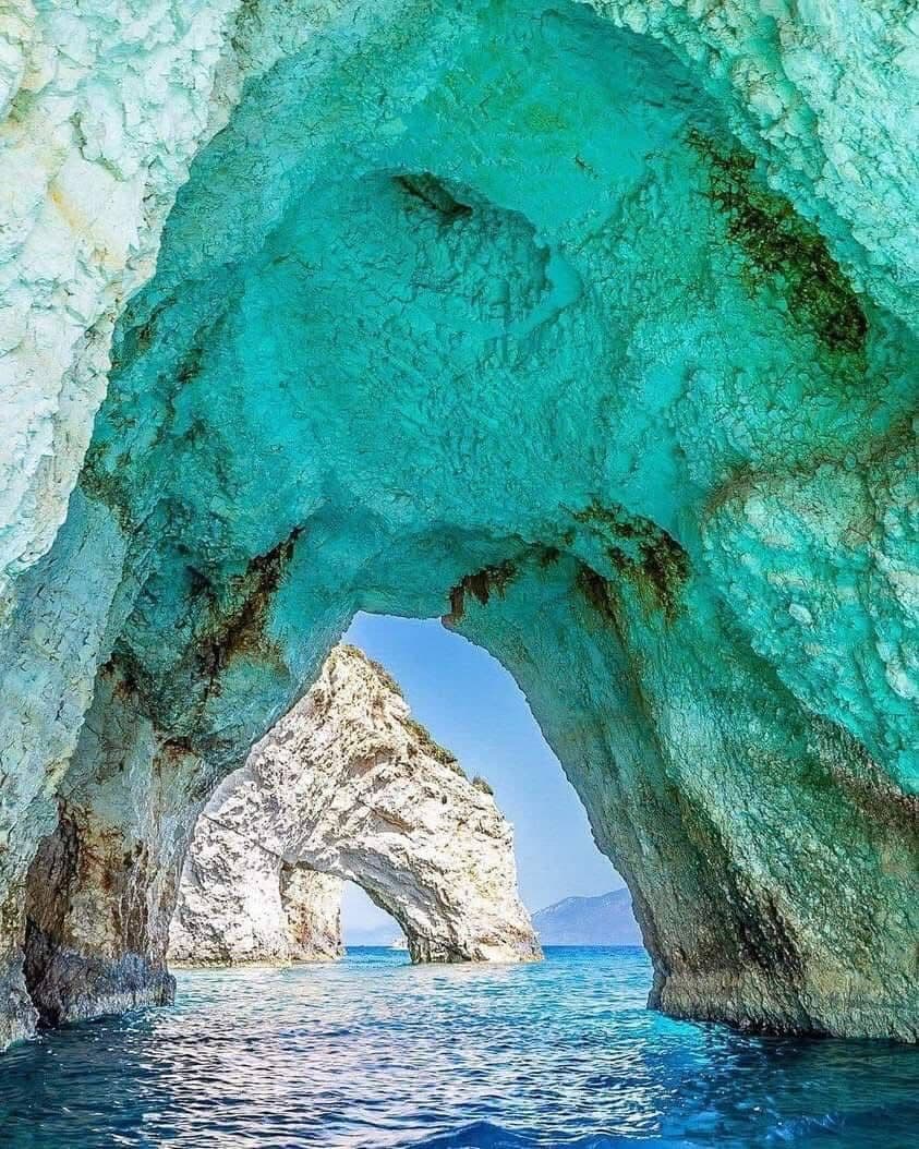 Electric blue light reflecting on the cave walls and turquoise water